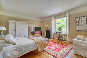a bedroom with a large bed and a living room at Berkeley House near Bath in Bath