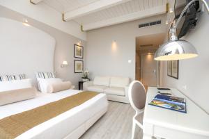 a white bedroom with a bed and a desk at Hotel Oliveto in Desenzano del Garda