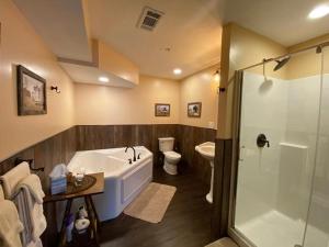 a bathroom with a tub and a toilet and a shower at The Swope Manor Bed & Breakfast in Gettysburg