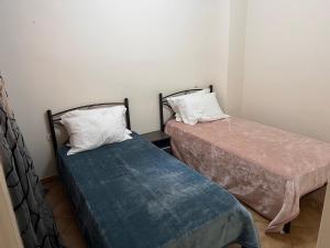 duas camas sentadas uma ao lado da outra num quarto em Cozerea Apartment em Atenas