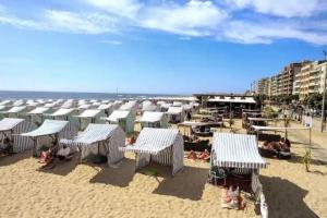 a beach with many umbrellas and people on the sand at Apartamento Matriz PVZ (T2) in Póvoa de Varzim