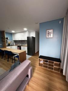 a living room with a couch and a table and a kitchen at Apartamento Matriz PVZ (T2) in Póvoa de Varzim