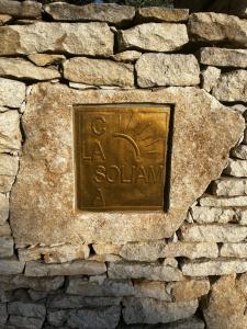 a metal plaque on a stone wall at La Casa Soliam in Bonifacio