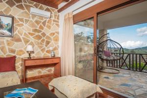 uma sala de estar com uma porta de vidro e uma varanda em The Stone House em Áyios Dhimítrios