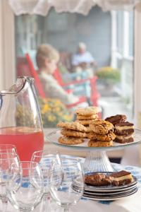 une assiette de biscuits sur une table avec des verres de vin dans l'établissement Brewster House Bed & Breakfast, à Freeport