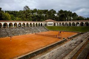 a tennis court in front of a building at Villa Emerald Oeiras Lisbon in Oeiras