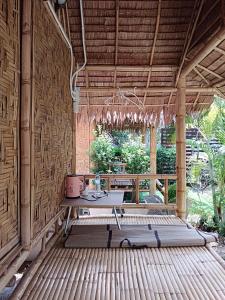 a room with a table on a wooden deck at Bamboo homestay at samroiyot in Baanphakrimlay 