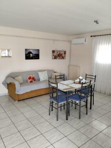 een woonkamer met een bank en een tafel en stoelen bij Maria's Modern Apartment , Monemvasia in Monemvasia