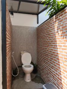 a bathroom with a toilet in a brick wall at Bamboo homestay at samroiyot in Baanphakrimlay 