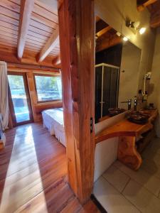 ein Bad mit einem Waschbecken und einem Spiegel im Zimmer in der Unterkunft Rocanegra Mountain Lodge in Las Trancas