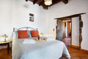 una camera da letto con un letto grande con cuscini arancioni di La casona de la rambla a San Juan de la Rambla Altre 37 foto