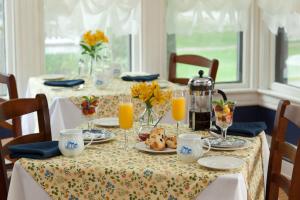 a table with food and orange juice on it at Brewster House Bed & Breakfast in Freeport