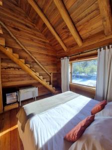 1 dormitorio con 1 cama en una cabaña de madera en Rocanegra Mountain Lodge, en Las Trancas