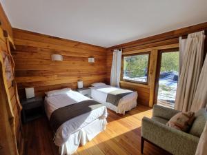a bedroom with two beds and a couch and a window at Rocanegra Mountain Lodge in Las Trancas