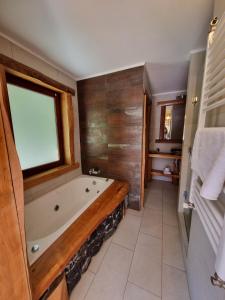 a bathroom with a bath tub and a window at Rocanegra Mountain Lodge in Las Trancas