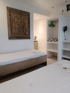 a bedroom with two white beds and a window at Salty SeaShells Skiathos in Skiathos