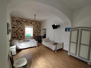 Bed And Breakfast Villa Bianca في أروسييْ: غرفة نوم بسريرين وجدار حجري