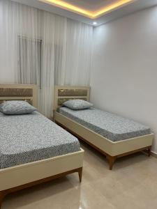 2 lits installés dans une pièce avec une loutre dans l'établissement Appartement ghammarth la marsa, à Gammarth