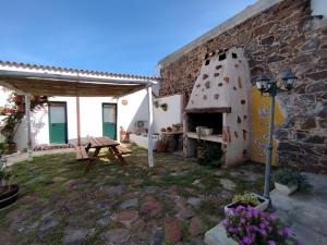 a patio with a table and a pizza oven at Bed And Breakfast Villa Bianca in Orosei