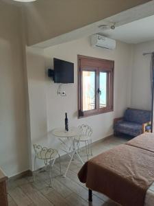 a bedroom with a bed and a table and chairs at DIOLKOS APARTEMENT in Nea Roda