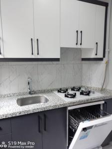 a kitchen with white cabinets and a sink at Atam Suites in Istanbul