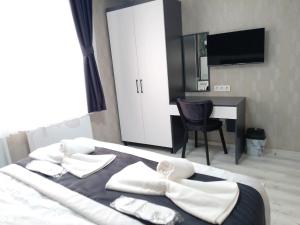 1 dormitorio con 1 cama con toallas blancas y escritorio en Atam Suites, en Estambul