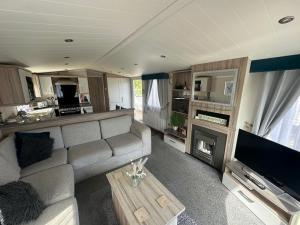 a living room with a couch and a fireplace at Lakeside Retreat 3 with hot tub, private fishing peg situated at Tattershall Lakes Country Park in Tattershall