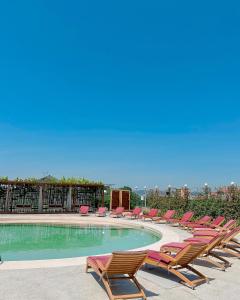 uma fila de espreguiçadeiras e uma piscina em Kronos Hotel em Durrës