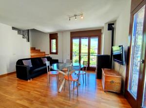 ein Wohnzimmer mit einem Glastisch und einer Couch in der Unterkunft Apartaments Sort Pirineus in Sort