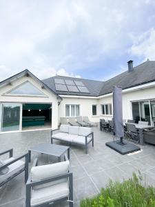 a patio with couches and a table and chairs at Villa de standing en Champagne in Fresnes-lès-Reims