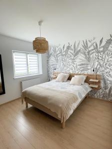a bedroom with a bed with a tropical wallpaper at Villa de standing en Champagne in Fresnes-lès-Reims