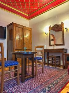 a room with a table and chairs and a mirror at Robin Hotel Apartments in Tsepelovo