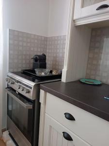 a kitchen with a stove and a black counter top at Στούντιο στο κέντρο της Πρέβεζας in Preveza +4 photos