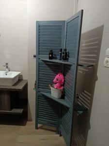 a blue shelf in a bathroom with a pink stuffed animal at Στούντιο στο κέντρο της Πρέβεζας in Preveza