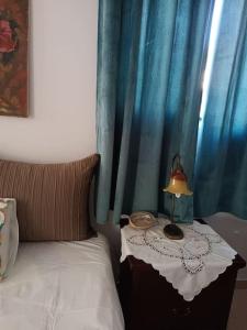 a bed with a table with a lamp on it at Στούντιο στο κέντρο της Πρέβεζας in Preveza