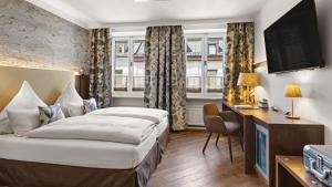 Pokój hotelowy z łóżkiem i biurkiem w obiekcie Hotel Deutsche Eiche w Monachium