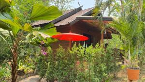 a red umbrella in front of a house at Nan Seasons Boutique Resort in Nan