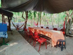 einen Tisch mit roten Stühlen unter einem Zelt in der Unterkunft Wellness & Fitness In Life La Union Postural & Joint Alignment Yoga Retreat Yoga Session Center 