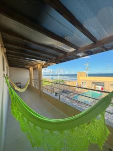 un balcón con hamaca y vistas a la playa en VIRASSOL Praia Hotel en Salvador
