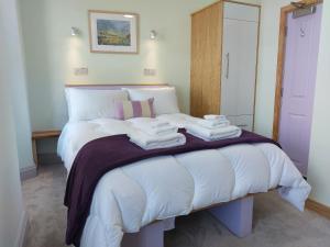 a bedroom with a bed with towels on it at Ellerhow in Windermere