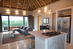 a kitchen and living room with a stove top oven at Villa Zazu in Hoedspruit