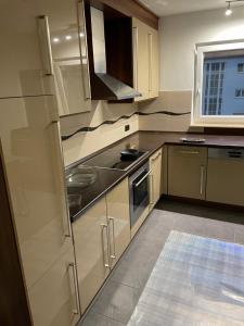 een keuken met witte kasten en een roestvrijstalen koelkast bij Zimmer in Wohnung mit Balkon in Gelnhausen