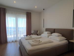 a bedroom with two beds and a large window at SmartStay Johnny in Podstrana