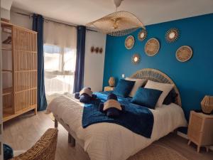 um quarto com uma cama grande e paredes azuis em Villa avec piscine intérieure proche des plages du debarquement em Escoville