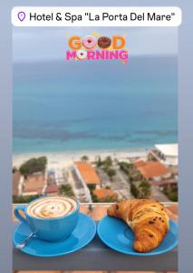 a picture of a cup of coffee and a croissant at La Porta del mare SPA in Tropea