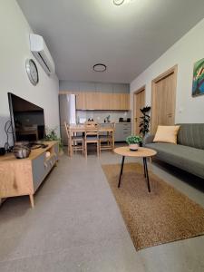 ein Wohnzimmer mit einem Sofa und einem Tisch in der Unterkunft modern apt near Heraklion city & airport in Néa Alikarnassós