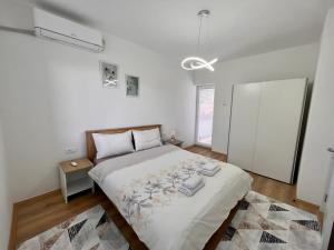 a bedroom with a large bed and a white wall at R&D Central Apartment in Prilep