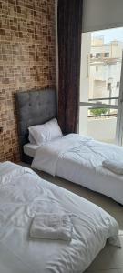 two beds in a room with a window at Appartement HASSANIA in Casablanca