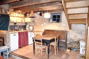cocina con mesa de madera en una habitación en Maison d'une chambre avec jardin amenage et wifi a Meyrignac l'Eglise a 3 km de la plage en Meyrignac-lʼÉglise