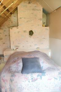 1 dormitorio con 1 cama con pared en Maison d'une chambre avec jardin amenage et wifi a Meyrignac l'Eglise a 3 km de la plage en Meyrignac-lʼÉglise